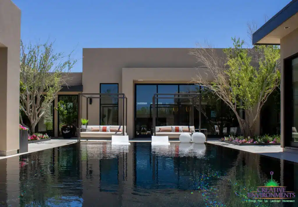 Custom backyard design with daybeds, baja step and zero-edge pool.