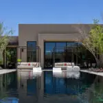 Custom backyard design with cabanas, black pool and organized planting.