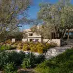 Custom backyard design with metal fencing, metal hand rail and organized planting.