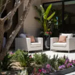 Custom backyard design with annuals, organized planting and outdoor seating area.