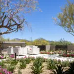 Custom backyard design with metal fencing, outdoor seating area and organized planting.