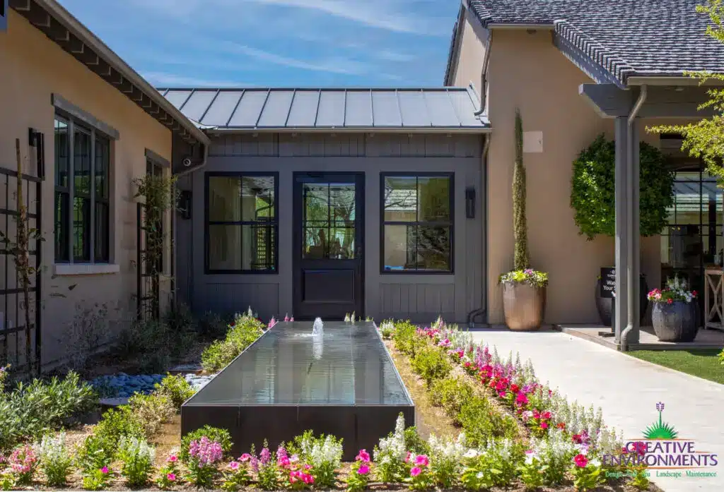 Custom backyard design with planters, metal trellis and water feature.