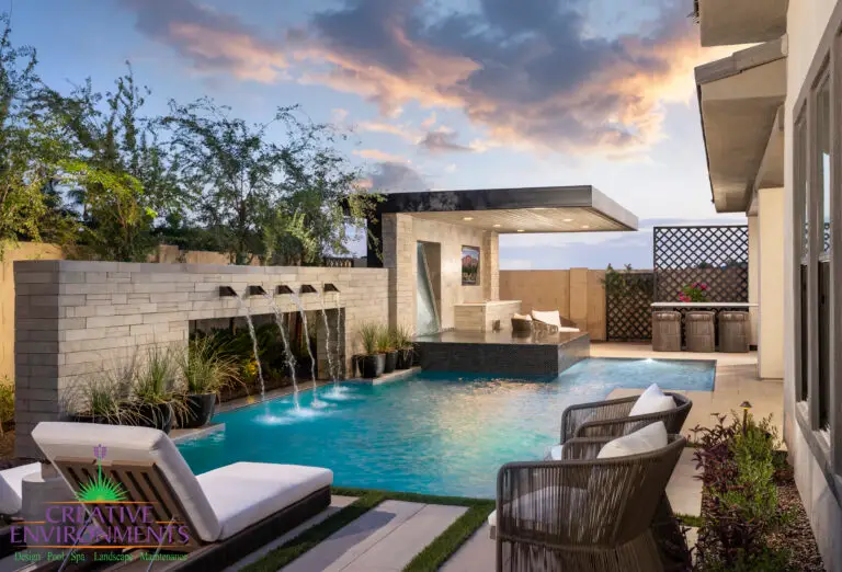 Custom backyard design with cantilevered shade structure and metal scupper water feature into unique-shaped pool.