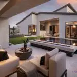 Custom backyard design with fire table, artificial turf and multiple seating areas.