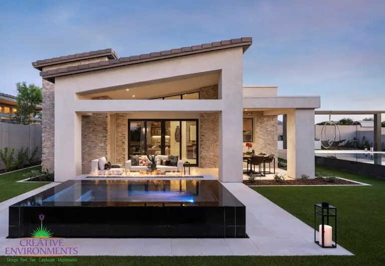 Custom backyard design with black tiled hot tub, artificial turf and hanging swing.