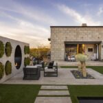 Backyard design with circular living wall, multiple seating areas and artificial turf.