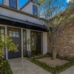 Custom front yard design with organized planting and potted plants.