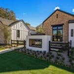 Custom front yard design with organized planting, built-in fireplace and metal gate.