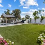 Custom backyard design with annuals, real grass and deco-tile pool.