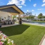 Custom backyard design with deco-tile pool, outdoor shade structure and annuals.