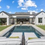 Custom backyard design with large pool, multiple grassy areas and deco-tile pool.