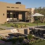 Custom backyard design with multiple seating areas, artificial grass and annuals.