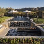 Custom backyard design with deco-tile sunken entertainment area, black pool and annuals.