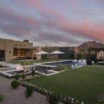 Custom backyard design with artificial turf, organized planting and shade structure.