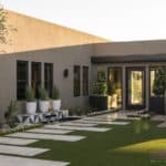 Custom backyard design with elevated, deco-tile platform water feature, large planters and cacti.