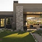 Custom backyard design with large planters, artificial turf and annuals.