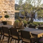 Custom backyard design with outdoor dining area, large planters and custom metal dividers.
