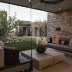 Custom backyard design with hanging couches, artificial grass and succulents.