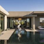 Custom backyard design with metal statement piece, zero-edge pool and desert plants.