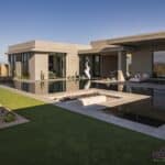 Custom backyard design with artificial turf, metal statement piece and sunken fire pit.