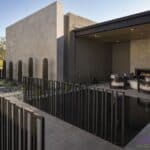 Custom front yard design with metal fencing, water feature and built-in fireplace.