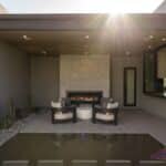 Custom seating area in front yard with fireplace, water feature and cacti.