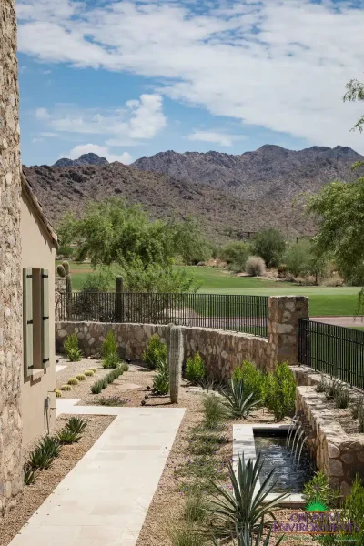 Custom backyard design with organized planting, natural stone accents and metal scupper water feature.
