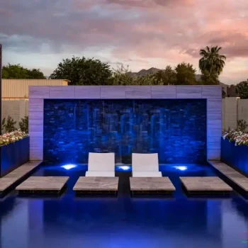 6006 (1) Custom backyard design with cabanas, Jesus steps and baja steps in front of water wall with blue water wall lighting.