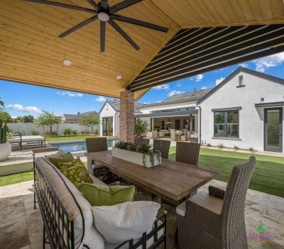 Custom backyard design with shade structure, outdoor fan and multiple seating areas.
