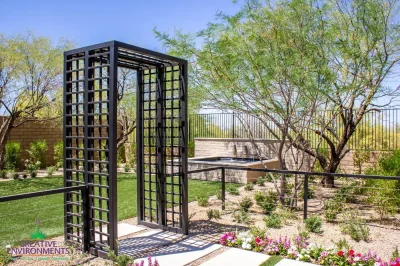 Custom metal archway, metal fencing and water feature in zen garden.