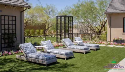 Custom backyard design with metal archway, water feature and lounge area.