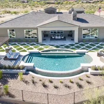 DJI_0039 Custom backyard design with artificial turf pattern, unique shaped pool and slatted shade structure.