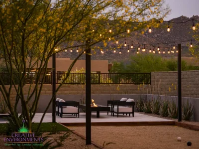 Custom backyard design with string lights, cantilevered fire table and bocce ball court.