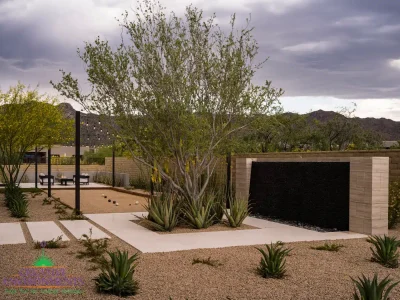 Custom backyard design with black water wall, organized planting and bocce ball court.