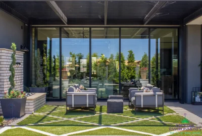 Custom backyard design with artificial turf pattern, topiaries and metal scupper water feature.
