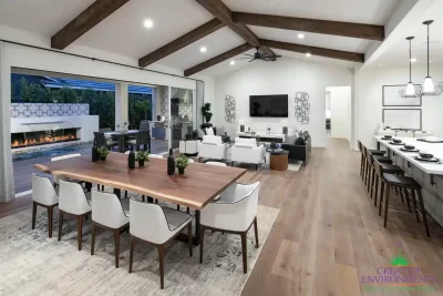 Custom indoor/outdoor living experience with deco-tiled water and fire feature into pool.