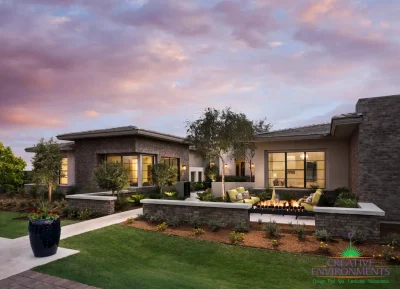 Custom front yard design with fire feature, up lighting and organized planting.