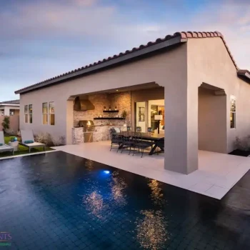 The Davidson Custom backyard design with zero edge pool with blue pool lighting and multiple seating areas.