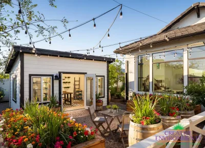 Custom backyard design with gardening area, string lighting and multiple planters.