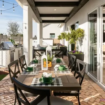 The Wayland Custom backyard design with multiple seating areas, metal planters and string lights.