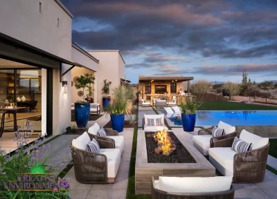 Custom backyard design with blue accents, shade structure and linear fire table.