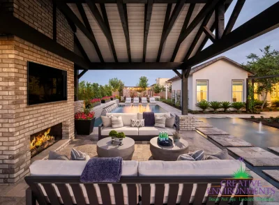 Custom backyard design with blue pool, Jesus steps and outdoor shade structure.